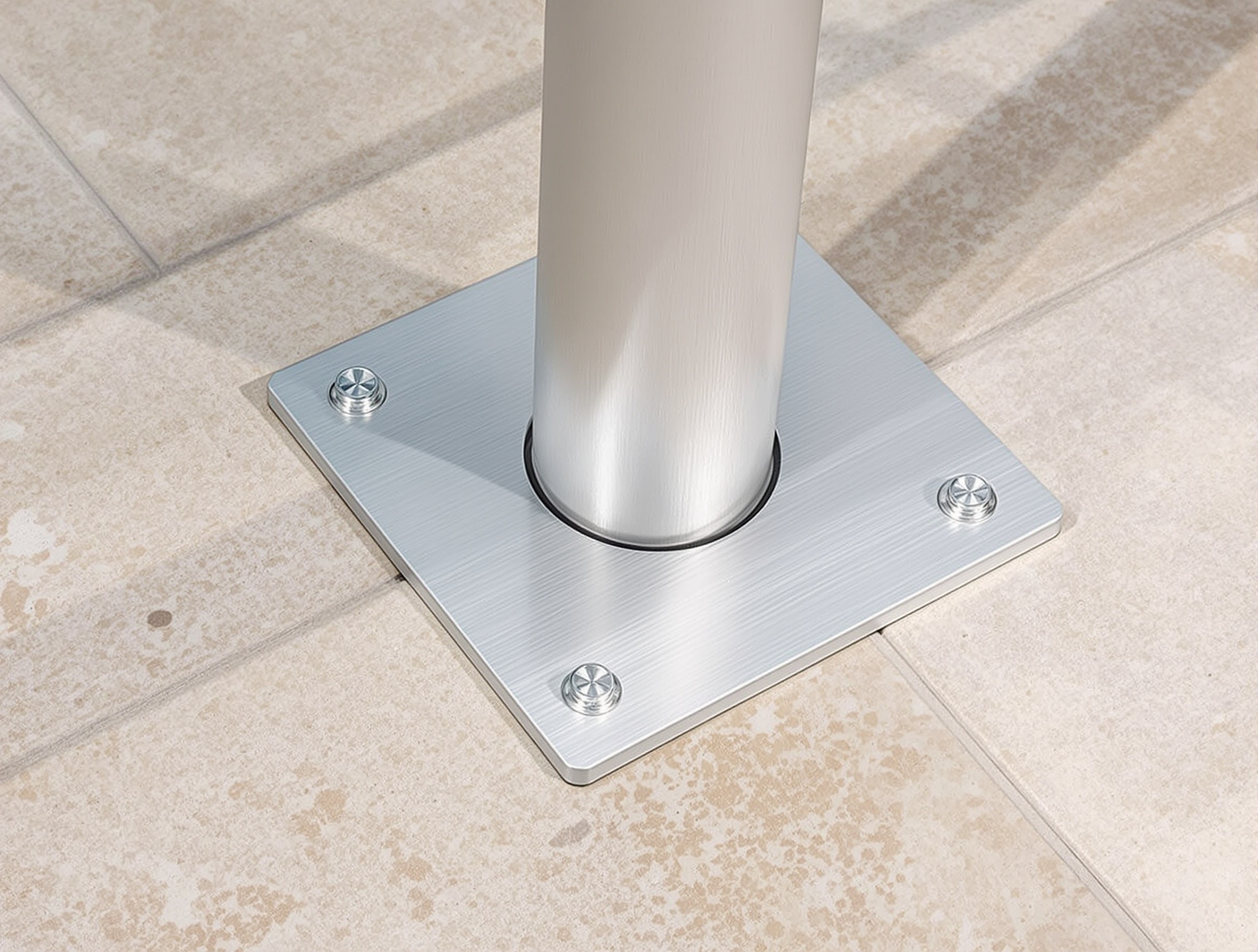 Platine de fixation barrière piscine vissée sur terrasse travertin