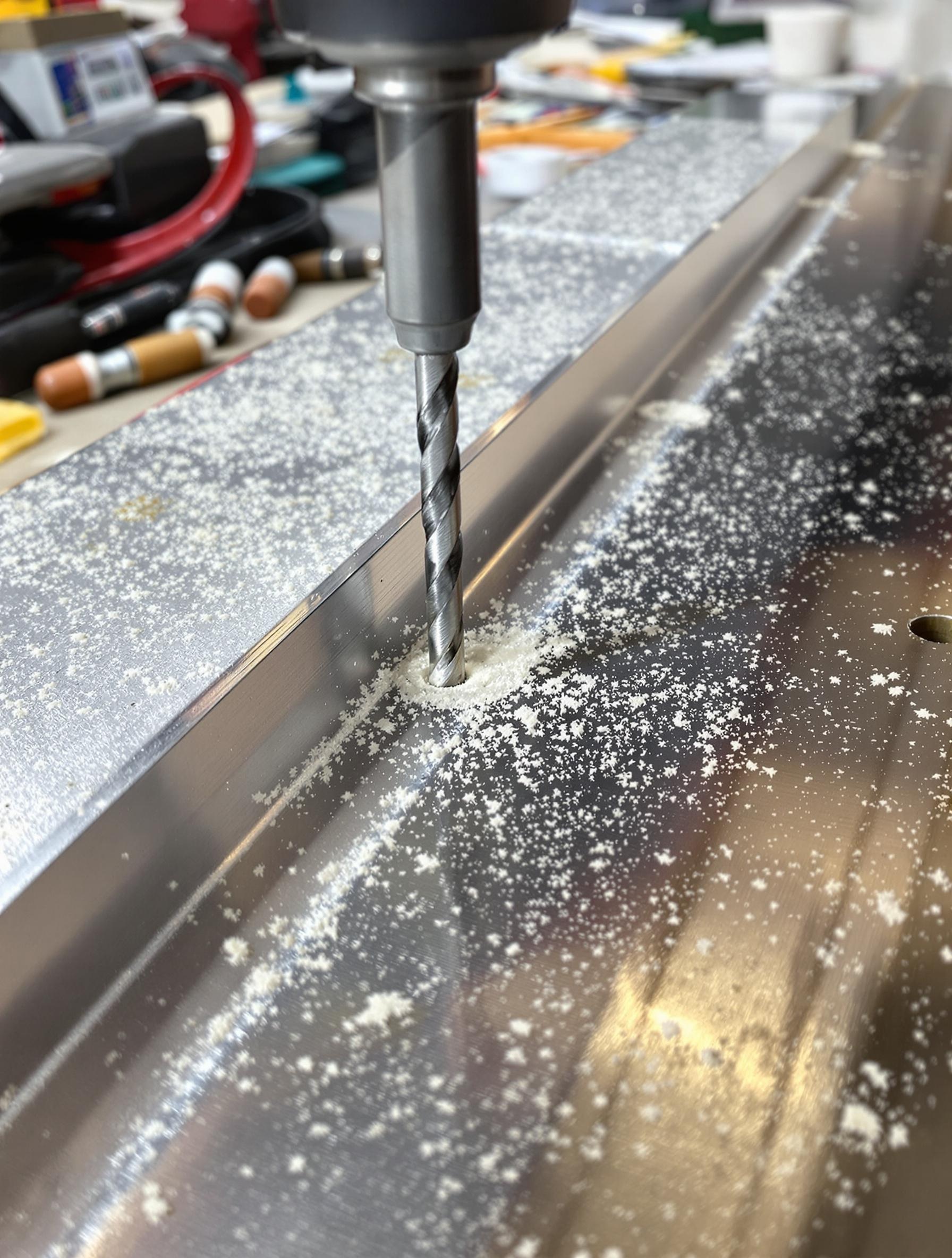 Gros plan sur pré-perçage baguette finition carrelage aluminium.