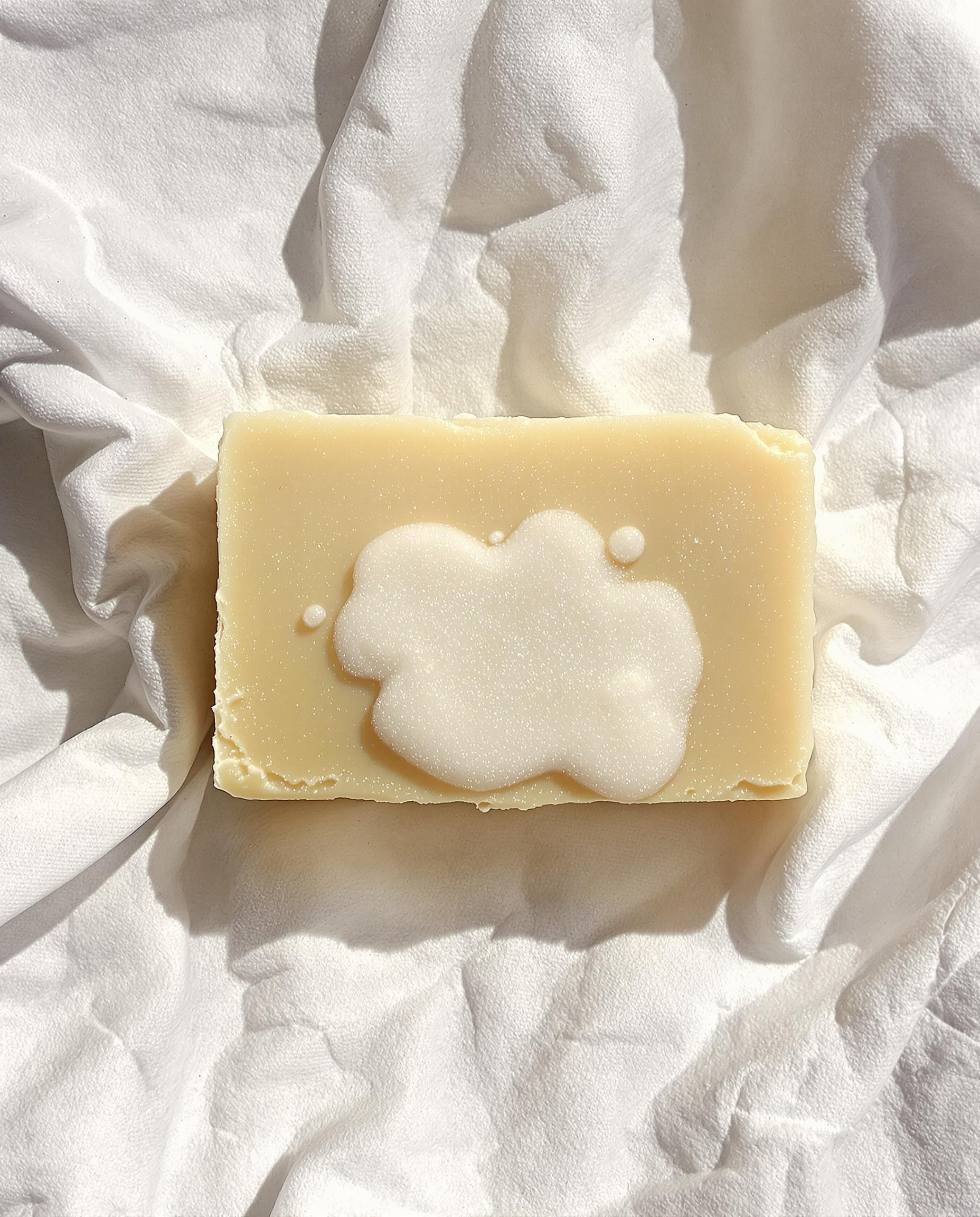 Savon de Marseille moussant sur une tache de linge blanc