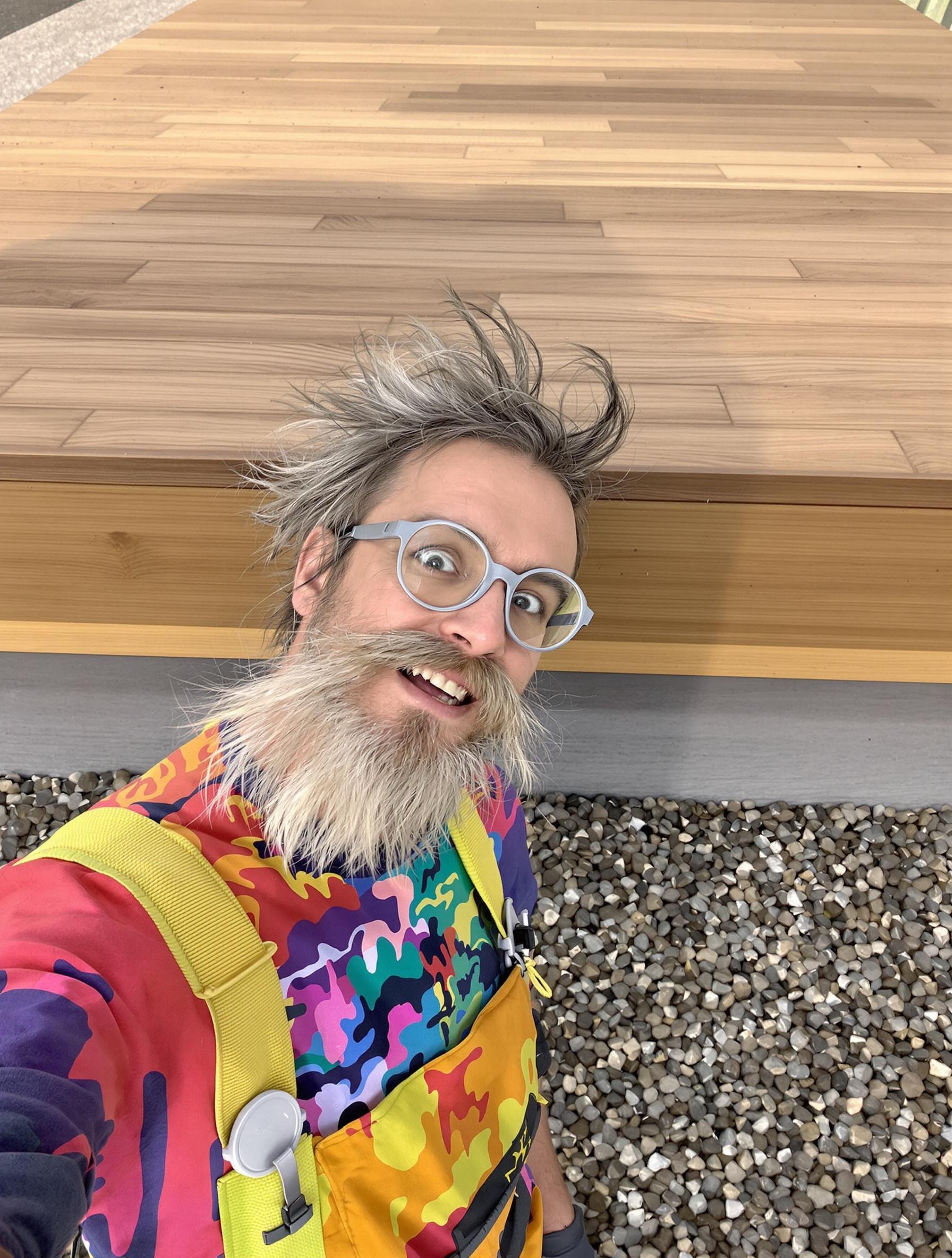 bricoleur excentrique prend selfie devant terrasse bois sur sol naturel