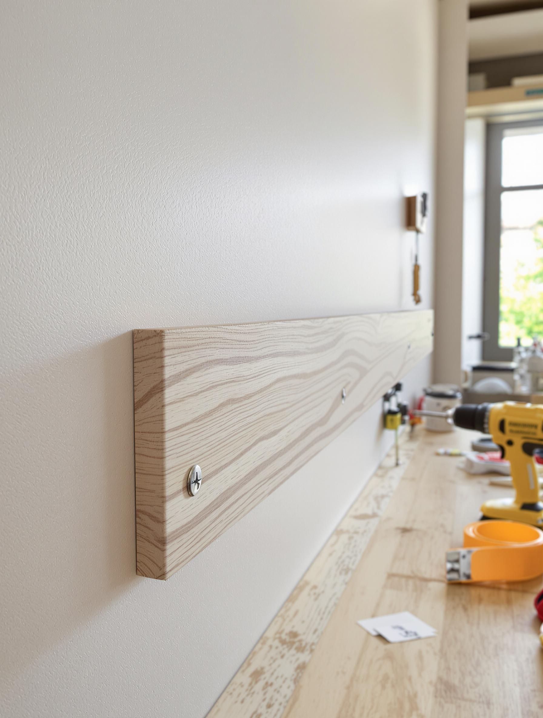 Tasseau bois vissé sur BA13 lors d’une rénovation – atelier outillage visible, lumière naturelle